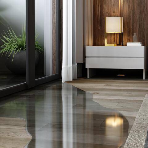 De l’eau pénètre par la baie vitrée et s’étale sur le parquet d’une chambre; table de chevet et plante en arrière-plan.